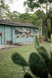 a blue building with flower pots on the side of it at Casinha à beira do arroio in Pelotas