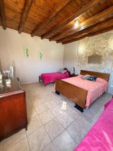 a bedroom with two beds and a stone wall at La tota casa de campo in Pocito