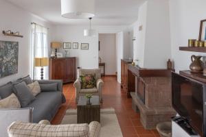 a living room with a couch and a tv at Casa da Manta in Fajã da Ovelha