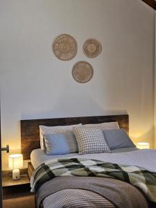 a bedroom with a bed with three plates on the wall at 12 Apostles Cottages - Tullarook in Princetown