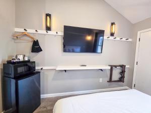 a bedroom with a tv on the wall and a bed at Penn Lodge Hotel & Suites Philadelphia - Bensalem in Bensalem