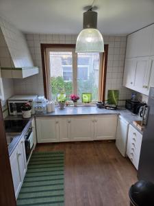 a kitchen with white cabinets and a large window at Peaceful Pad in Brussels