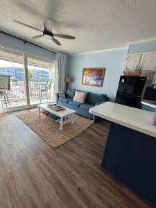 a living room with a blue couch and a table at Boltons Bungalow Casa Del Mar in Galveston
