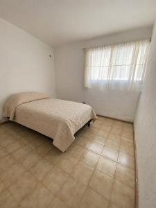 a white bedroom with a bed and a window at Casa TiaMaria - Centro San Rafael in San Rafael +4 photos