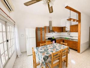 a kitchen with a table with chairs and a refrigerator at Casa TiaMaria - Centro San Rafael in San Rafael