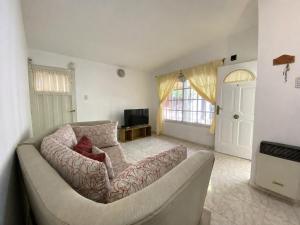 a living room with a couch and a television at Casa TiaMaria - Centro San Rafael in San Rafael