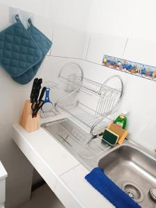 a kitchen sink with a dish drying rack next to it at Residencia Multifamiliar Sammy in Trujillo