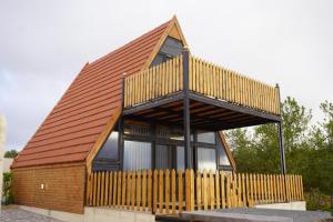 a small wooden house with a brown roof at Al Joud Chalet Private Jacuzzi & BBQ Ajloun in Ajloun