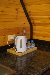 a kitchen counter with a toaster and bottles of water at Al Joud Chalet Private Jacuzzi & BBQ Ajloun in Ajloun