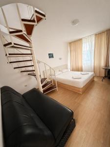a living room with a couch and a spiral staircase at Siana House in Ravda