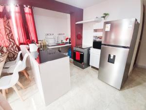 a kitchen with a stainless steel refrigerator and a table at Residencia Multifamiliar Sammy in Trujillo