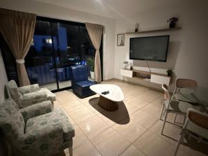a living room with a couch and a tv at Lindo Departamento con Terraza Vista al Mar in Pimentel