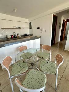 a glass table and chairs in a kitchen at Lindo Departamento con Terraza Vista al Mar in Pimentel