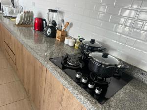 two pots and pans on a stove in a kitchen at Lindo Departamento con Terraza Vista al Mar in Pimentel +14 photos