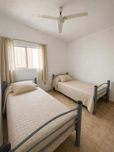 a bedroom with two beds and a ceiling fan at Casa Esquina - Centro San Rafael in San Rafael +4 photos