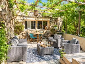 a patio with wicker chairs and a table in a yard at Salvacintoggio -Votre Villa avec Piscine Privée- in Porto-Vecchio