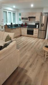 a living room with a couch and a kitchen at Escale 1 Spacieux avec CLIM in Tartas
