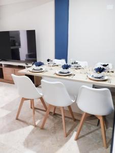 a dining room with a table and white chairs at Residencia Multifamiliar Sammy in Trujillo +110 photos