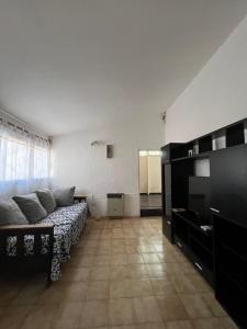 a living room with a couch and a television at Casa Esquina - Centro San Rafael in San Rafael