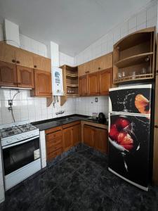 a kitchen with wooden cabinets and a black refrigerator at Casa Esquina - Centro San Rafael in San Rafael