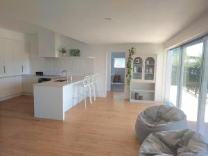 a white kitchen with a table and a couch in a room at Inner city Sanctuary in Gisborne