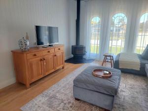 a living room with a tv on a wooden dresser at Inner city Sanctuary in Gisborne