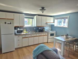 a kitchen with white cabinets and a table with a tableablish at Logis des prodiges - Le 775 in Rouyn-Noranda