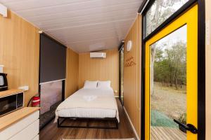 a bedroom in a tiny house with a large window at The Tiny Chalet by Tiny Away in Bromfleet