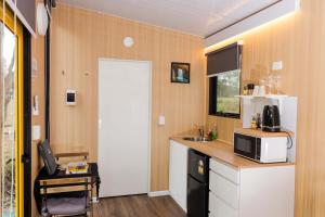 a kitchen with a sink and a counter with a microwave at The Tiny Chalet by Tiny Away in Bromfleet