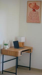 a wooden desk with a laptop on top of it at Petite Ancre in Le Gosier +7 photos