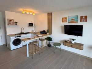 a room with a kitchen with a sink and a washing machine at Petite Ancre in Le Gosier