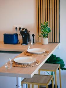 a table with two plates and wine glasses on it at Petite Ancre in Le Gosier