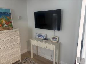 a room with a table with a tv on a wall at Seaside Retreat Cottages #1 in Clearwater Beach