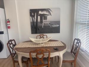 a dining room table with chairs and a picture on the wall at Seaside Retreat Cottages #1 in Clearwater Beach