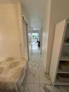 a bedroom with a bed and a tiled floor at Le Cocon Bleu in Le Moule