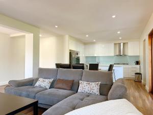 a living room with a couch and a kitchen at Doncaster Westfiled House 4BD in Doncaster