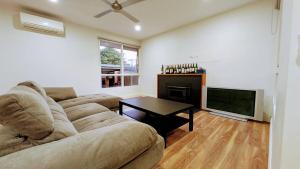 a living room with a couch and a television at Doncaster Westfiled House 4BD in Doncaster