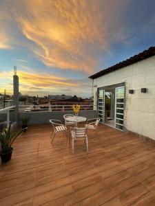 a patio with a table and chairs on a deck at New House Temporada in João Pessoa