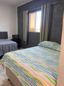 a bedroom with a colorful bed and a window at New House Temporada in João Pessoa
