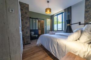 a bedroom with a white bed and a window at Le 10, Reflets dans l'Eau in Saint-Clair-de-la-Tour +26 photos