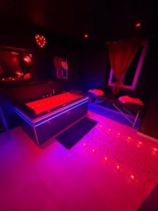 a dark room with a pool table and red lights at La nuit éternelle in Amilly