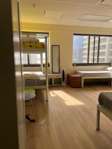 a room with bunk beds in a building with a window at Garden Hostel in Auckland +51 photos