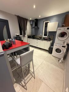 a kitchen with a red counter and a washing machine at La nuit éternelle in Amilly