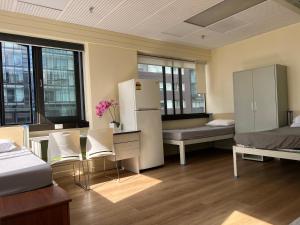 a dorm room with a bed and a refrigerator at Garden Hostel in Auckland