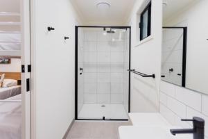 a bathroom with a shower with a glass door at Coomera Lodge Hotel in Gold Coast +13 photos