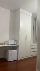 a kitchen with white cabinets and a microwave at Ap Aconchego in Campinas