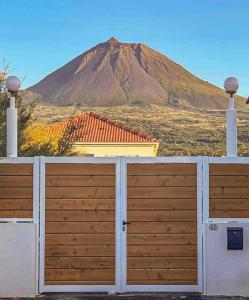 a house with a fence with a mountain in the background at Casa Dos Arcos Oceanfront Apartments in Arcos