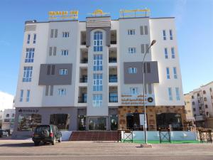 ein Gebäude mit einem davor geparkt in der Unterkunft Wanasa Inn Apartments in Mawāliḩ