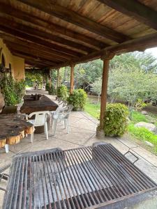 a patio with a table and chairs and a grill at Cabaña el nido del monte in Tapalpa