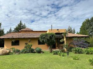 a house with a garden in front of it at Cabaña el nido del monte in Tapalpa